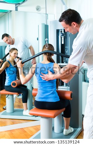 Patient at the physiotherapy making physical exercises with her therapist