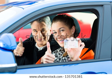 Driving School - Young woman steer a car, maybe she has a driving test, she holding proudly her driving license then she has passed