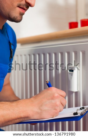 Technician reading the heat meter to check consumption