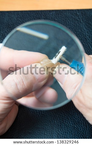 hearing aid acoustician at work, he is working on a hearing aid for hearing impaired persons