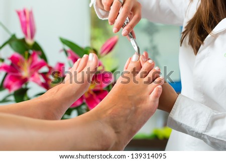Woman receiving pedicure in a Day Spa, feet nails get cut and filed