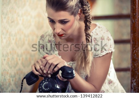 Woman sitting on the stairs waiting for a call and looking unhappy