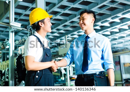 Worker or production manager and owner, ceo or controller shake hands in a factory