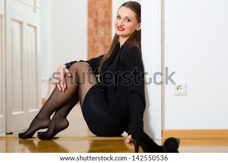 Online Dating - Young businesswoman sitting at home on the floor while using a tablet computer for online dating