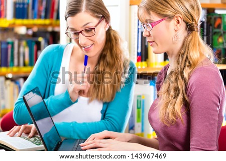 Students - Young women in library with laptop and book learning in group