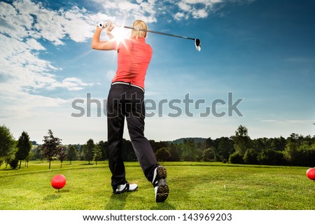 Young female golf player on course doing golf swing, she presumably does exercise