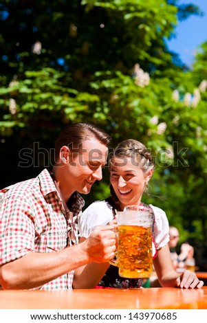 Happy Couple sitting in Beer garden and enjoy the beer and the sun