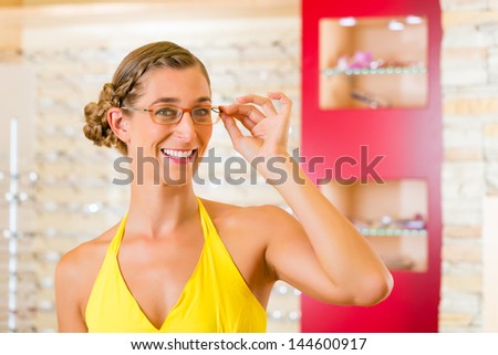 Young woman at optician with glasses, she might be customer or salesperson