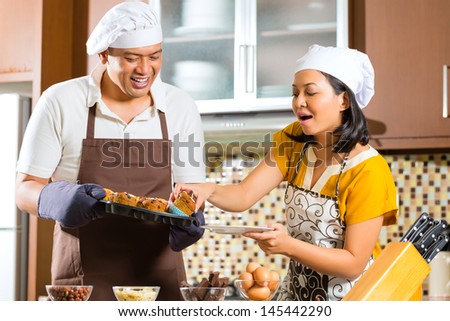 Asian couple, man and women, baking homemade cake in his kitchen for dessert