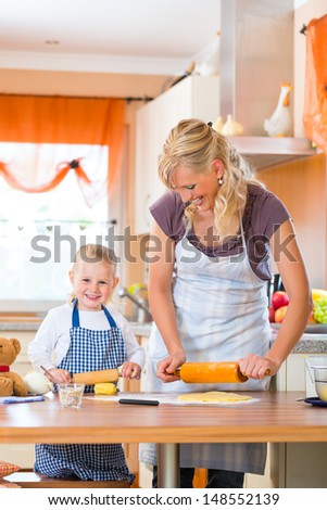 Family home baking - Mother and daughter baking cookies together at home