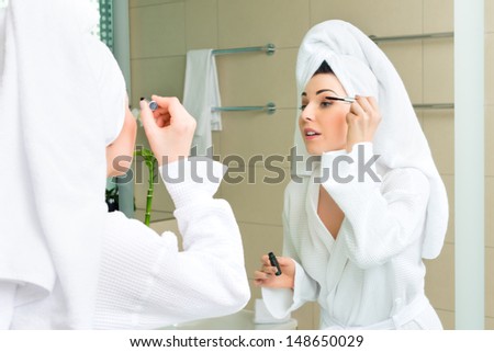 Young woman in the hotel bathroom, suite, refreshing herself and apply makeup