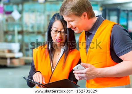 Logistics Teamwork Worker or warehouseman and his female coworker with tablet computer at warehouse of freight forwarding company Logistics Teamwork Worker or warehouseman and his female coworker with tablet computer at warehouse of freight forwarding company