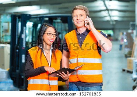 Logistics Teamwork - Worker or warehouseman and his female coworker with tablet computer at warehouse of freight forwarding company