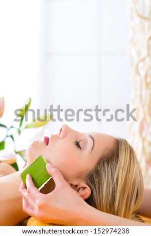 Wellness - woman receiving head or face massage whit aloe Vera in spa