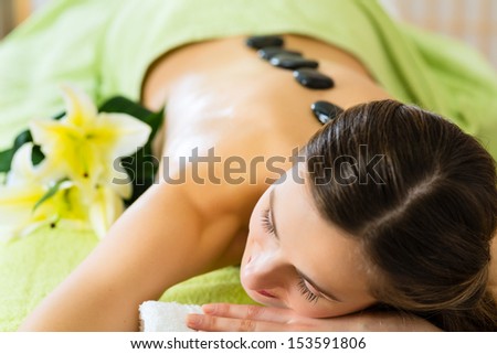 Beautiful woman having a wellness hot stone back massage