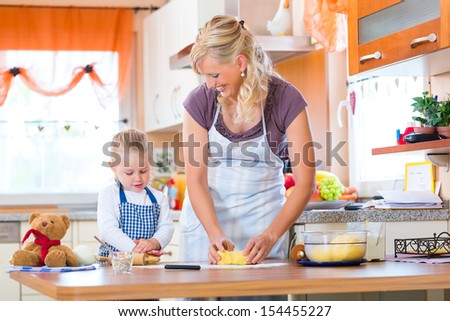 Family home baking - Mother and daughter baking cookies together at home