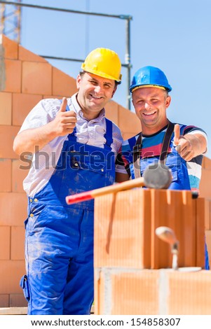 Construction site worker building a home or house doing bricklaying work on the walls of the shell