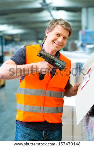 Logistics - Warehouseman with protective vest and scanner, scans bar-code of package, he standing at warehouse of freight forwarding company