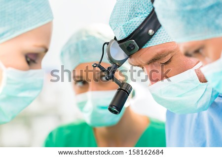 Hospital - surgery team in the operating room or Op of a clinic operating on a patient, perhaps it\'s an emergency