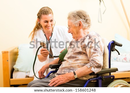 Young Nurse And Female Senior In Nursing Home, The Blood Pressure Is Going To Be Measured