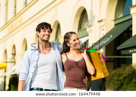 Young couple shopping in inner with shopping bags spending money