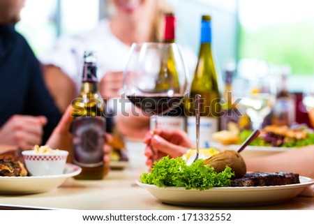 Friends or couples eating fast food and drinking beer and wine in a American fast food diner
