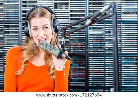 Female Presenter or host in radio station hosting show for radio live in Studio