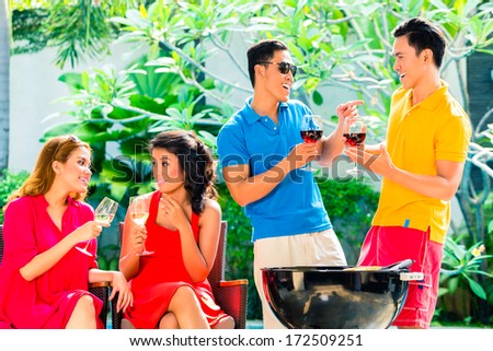 Asian friends having barbecue or BBQ at pool, drinking  wine and celebrating summer time