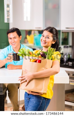 Young Asian handsome woman coming home from grocery shopping