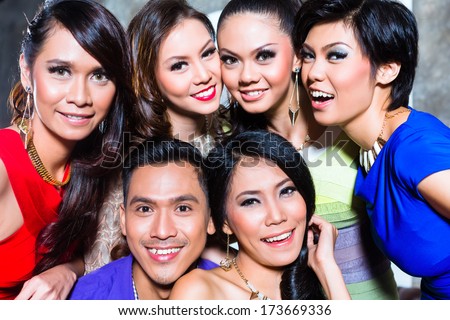 Asian young and handsome group of party people or friends taking pictures in fancy night club