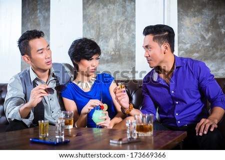 Asian party people man harass woman with her boyfriend in night club by inviting her to a drink