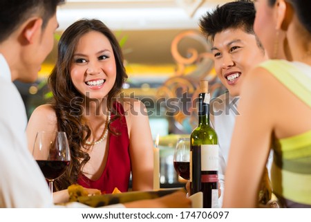 Four Asian Chinese business people having dinner in elegant club restaurant or hotel Four Asian Chinese business people having dinner in elegant club restaurant or hotel