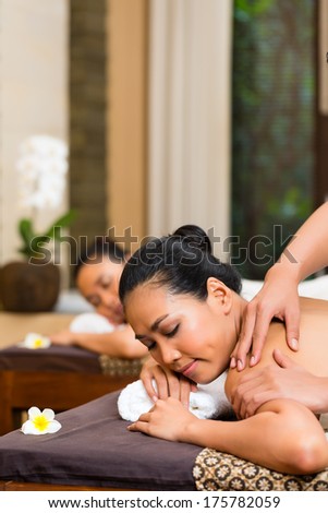 Two Indonesian Asian women in wellness beauty spa having aroma therapy massage with essential oil, looking relaxed