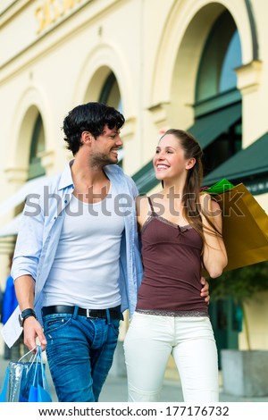 Young couple shopping in inner city with shopping bags spending money