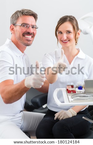 Successful Dentists in their surgery looking at the viewer standing side by side