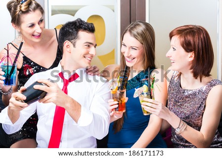 Friends drinking with barkeeper cocktails in fancy night club