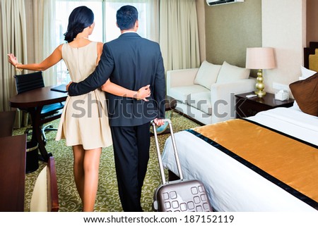 Rear view of couple arriving to hotel room