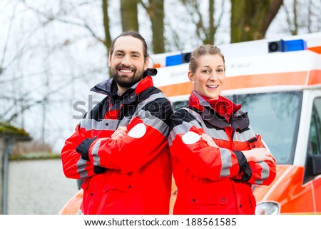 Emergency doctor and nurse standing in front of ambulance car