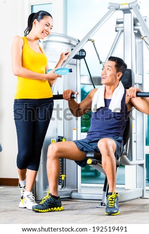 Young woman and man chatting at gym