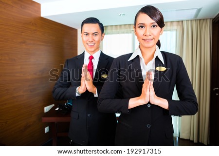 Portrait of hotel staff greeting with hands put together