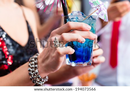 Woman drinking cocktails in fancy night club