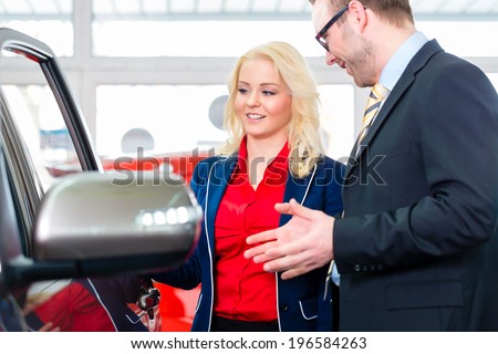 Woman looking at car in auto dealership