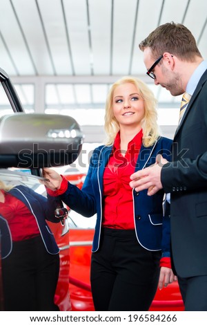 Woman looking at car in auto dealership