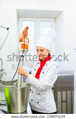 Female Chef preparing ice cream with food processor in gastronomy parlor kitchen
