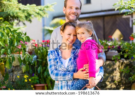 Mother, father and daughter in garden with basket