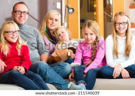 Family sitting together with mother, father and children comfortable on sofa