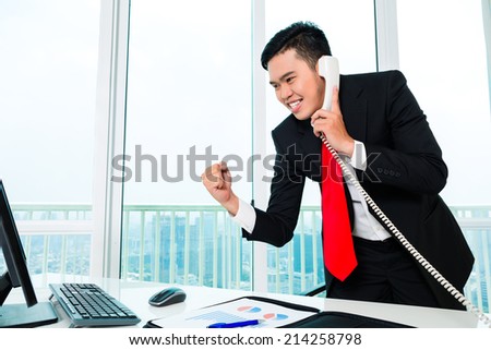 Asian business man telephoning in office controlling profit