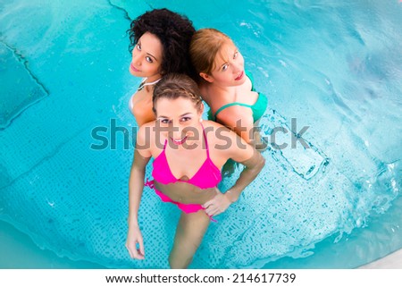 Friends wearing bikinis bathing in swimming pool