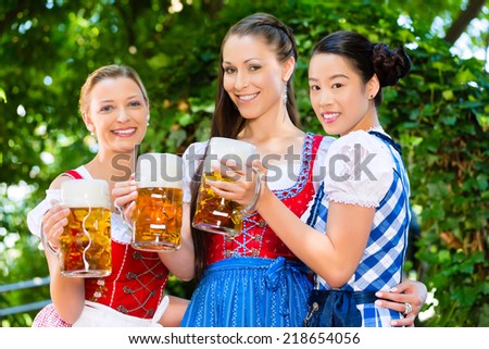 In Beer garden - female friends in Tracht, and Dirndl in Bavaria, Germany