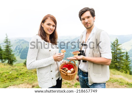 Mushrooms - young couple looking and searching for porcini in the mountains